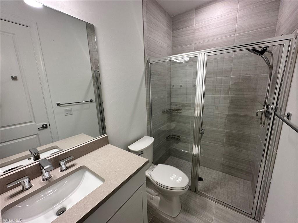 Full bath featuring a shower stall and vanity