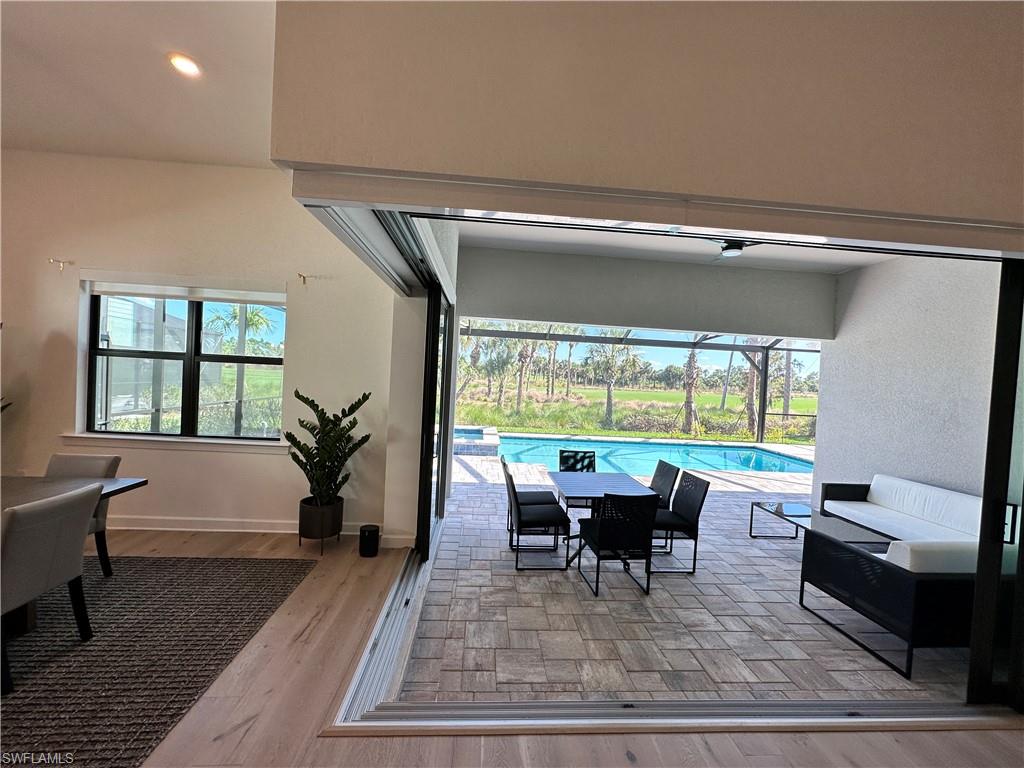 Dining area with light wood-style floors, a sunroom, and recessed lighting
