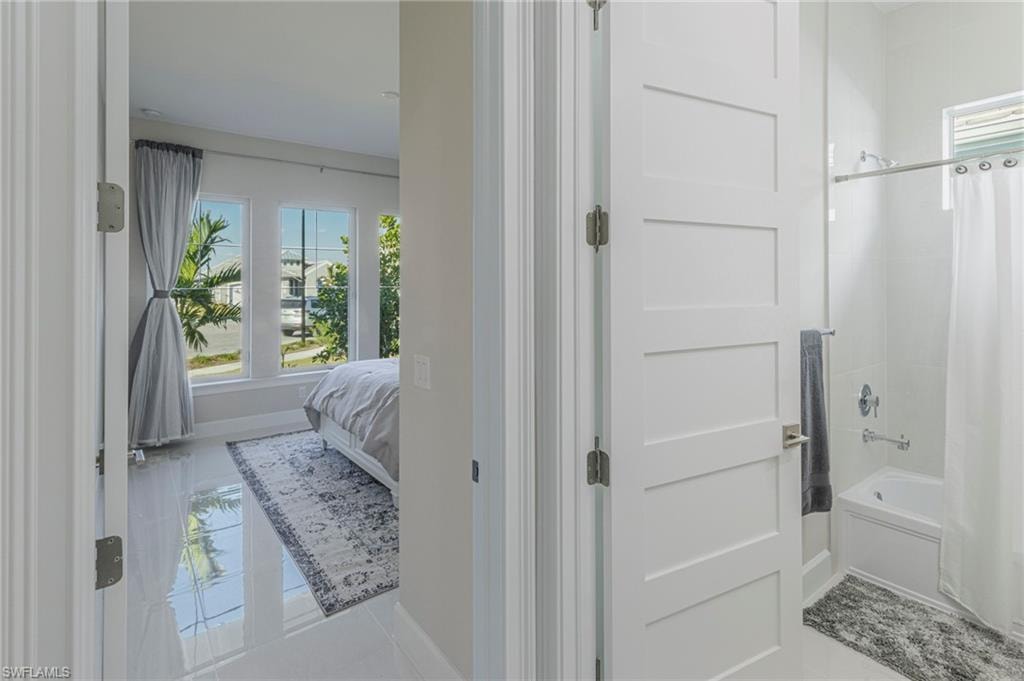 Bathroom with tile patterned floors and shower / bathtub combination with curtain