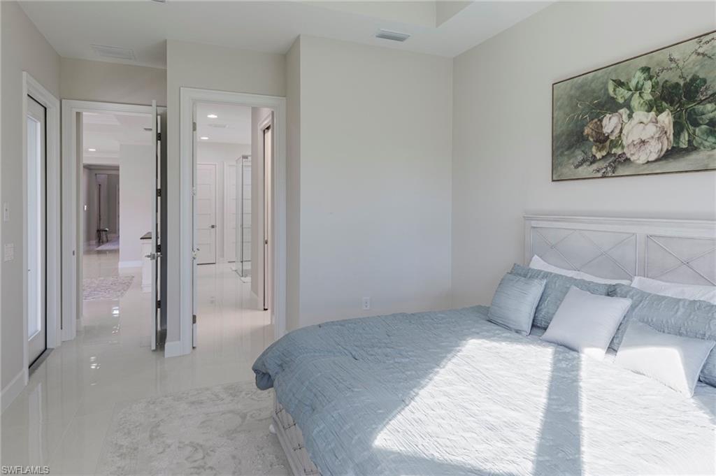 Bedroom featuring light tile patterned floors and connected bathroom