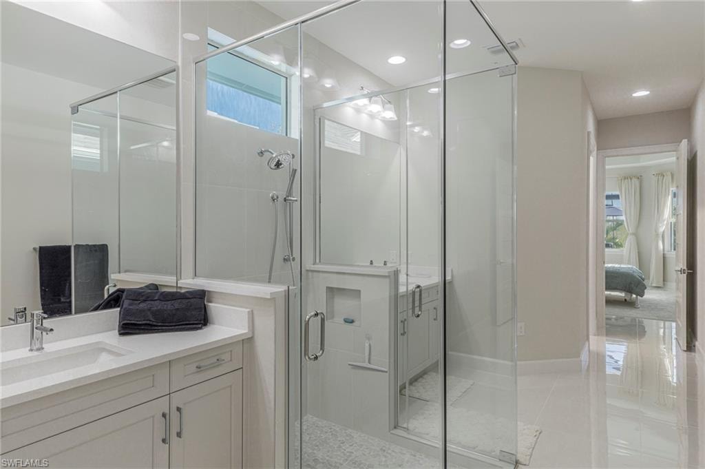 Bathroom with vanity, a healthy amount of sunlight, and an enclosed shower