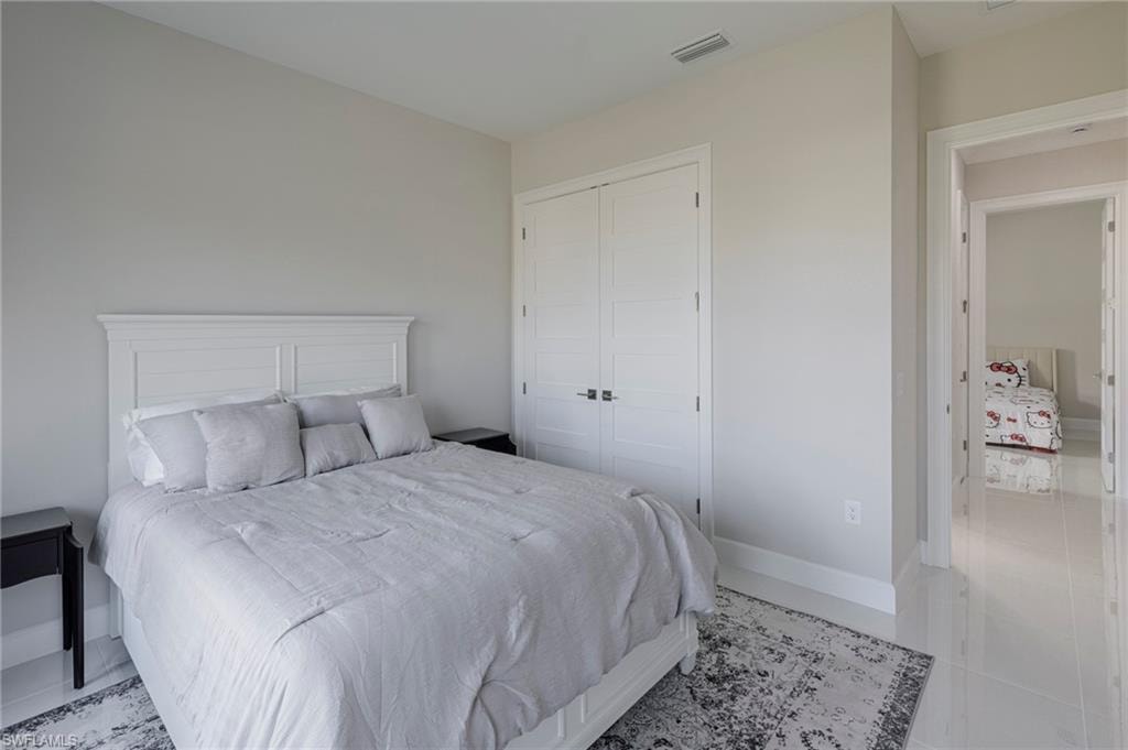 Tiled bedroom with a closet