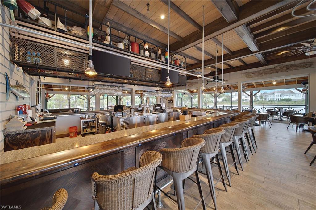 Bar with beamed ceiling, hanging light fixtures, plenty of natural light, and wood ceiling