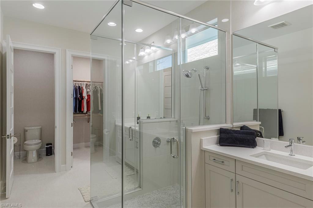 Bathroom with vanity, toilet, and an enclosed shower