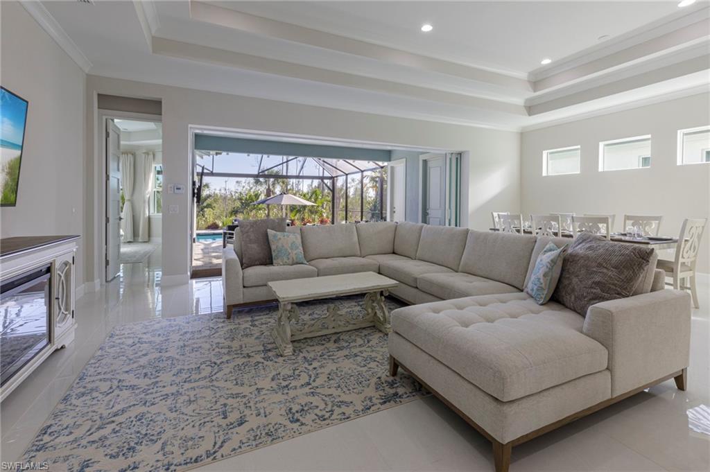 Living room featuring plenty of natural light, ornamental molding, and light tile patterned floors