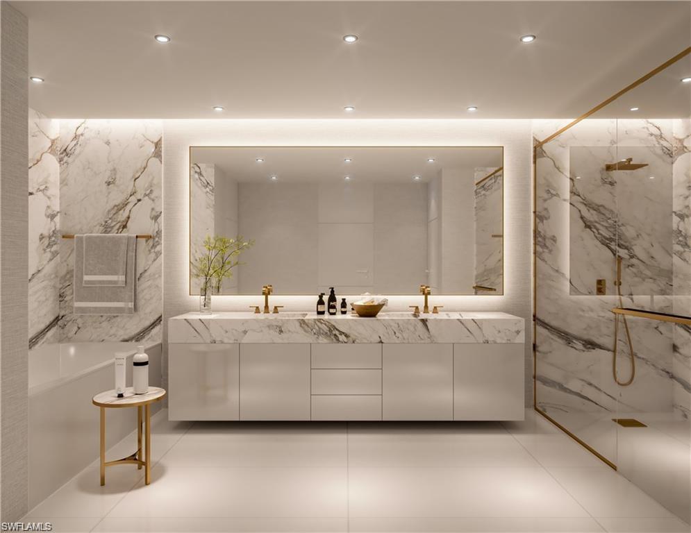 Bathroom with double vanity, a marble finish shower, stone wall, a freestanding tub, and recessed lighting