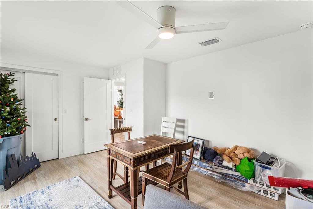 Light wood-style flooring and a ceiling fan