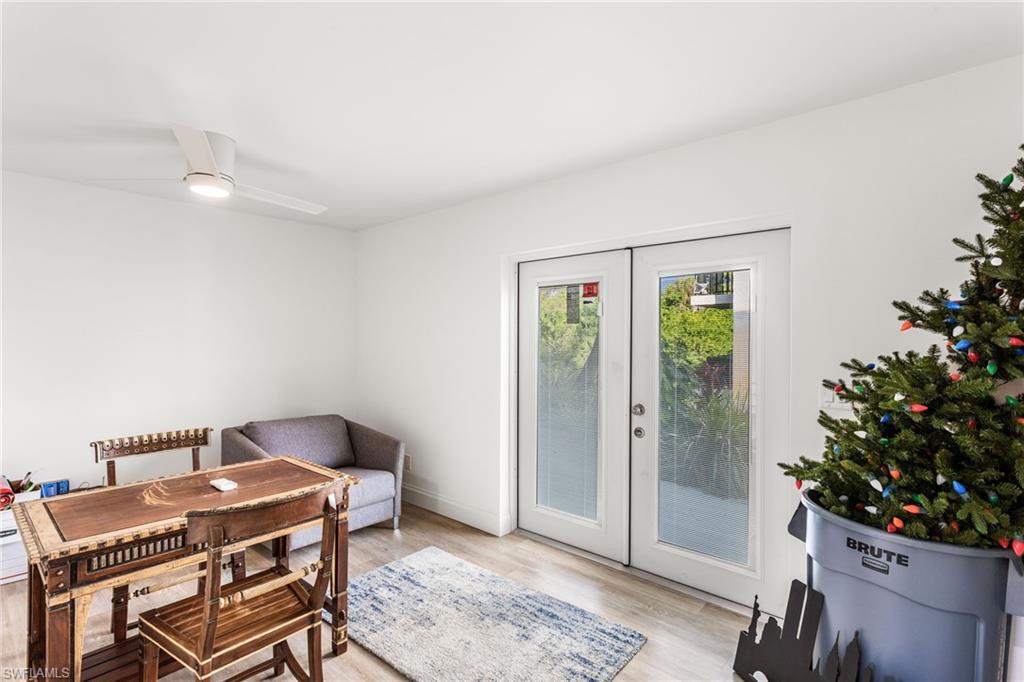 French doors, light wood-style flooring, and a ceiling fan