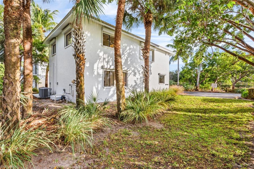 View of home's exterior with stucco siding and a yard