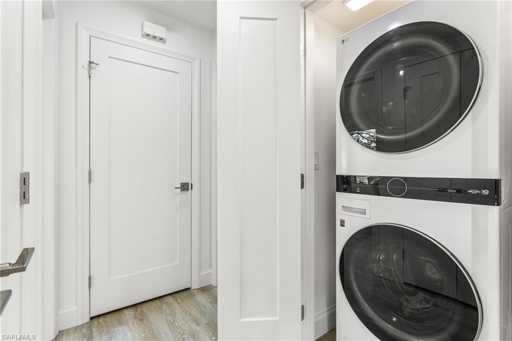 Laundry room featuring estacked washer and dryer and light wood-style floors