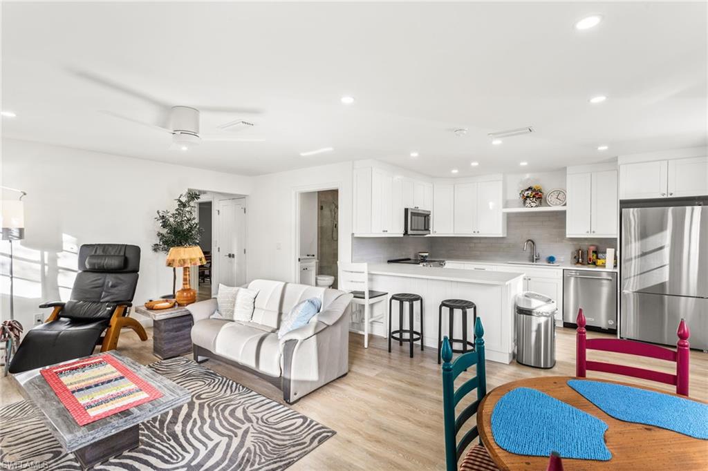 Living area with light wood-style flooring and recessed lighting