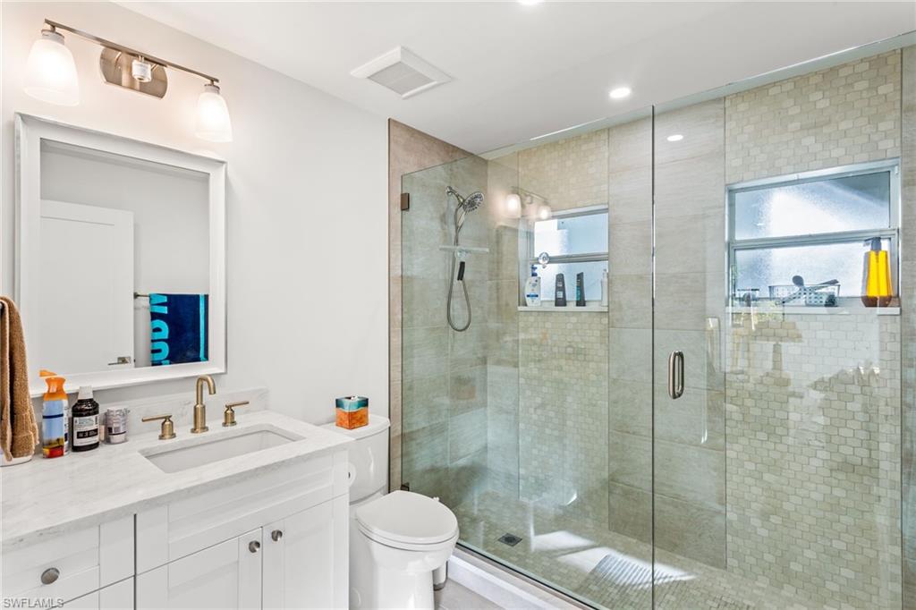 Full bath with vanity, a stall shower, and recessed lighting