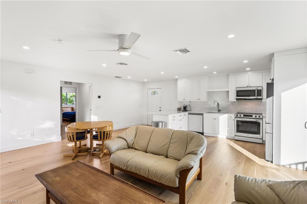 Living room featuring recessed lighting, ceiling fan, and light wood flooring