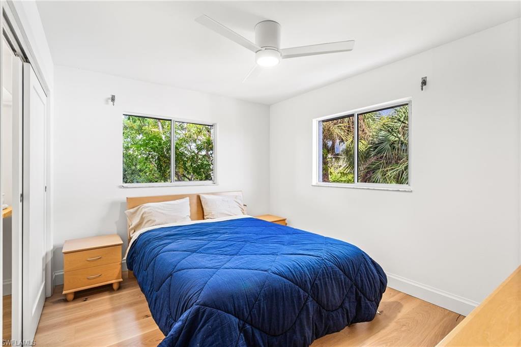 Bedroom with a closet, wood finished floors, and a ceiling fan