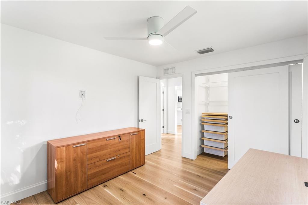 Office or second bedroom with light wood floors and ceiling fan
