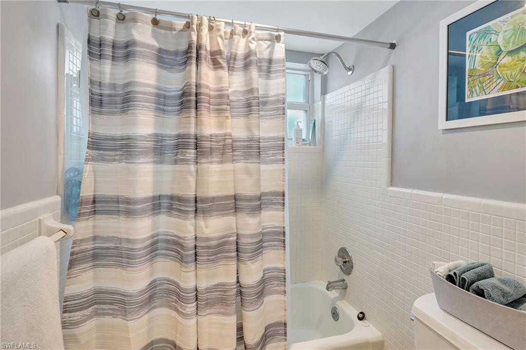 Master Bathroom with, tile walls, and shower / tub combo