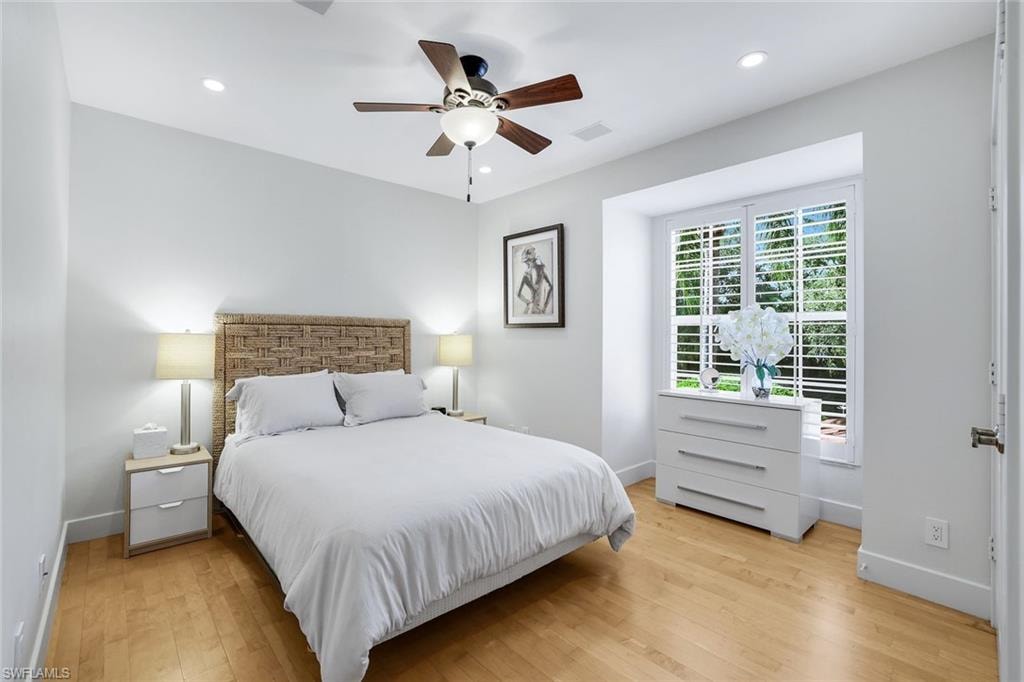 Bedroom with light wood-style flooring, a ceiling fan, and recessed lighting