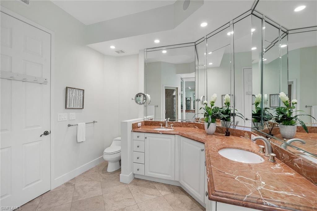 Full bath featuring double vanity, recessed lighting, and light tile patterned flooring