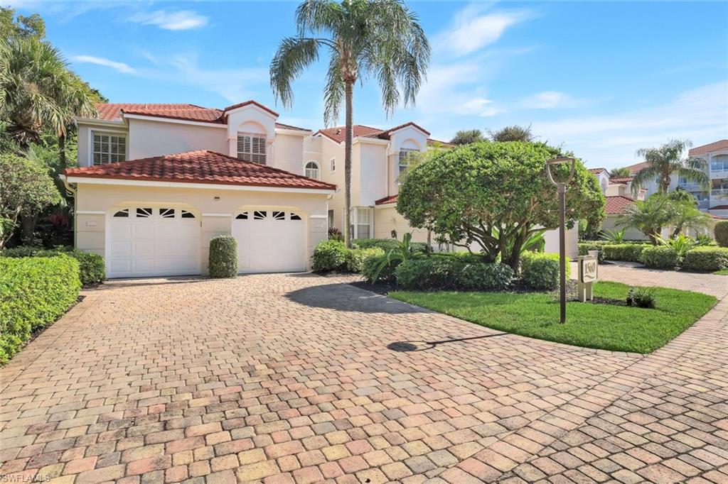 Mediterranean / spanish home with decorative driveway, stucco siding, a garage, and a front lawn