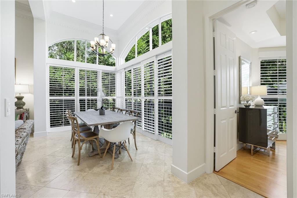 Dining area featuring healthy amount of natural light, crown molding, and a chandelier