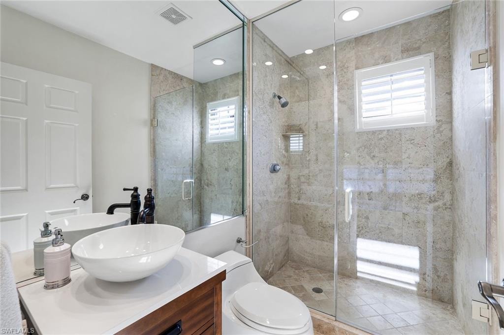 Bathroom featuring a stall shower, vanity, and recessed lighting