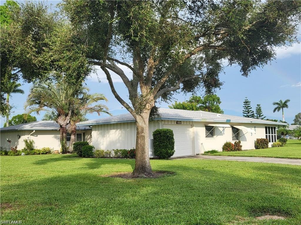 Ranch-style house with an attached garage and a front yard