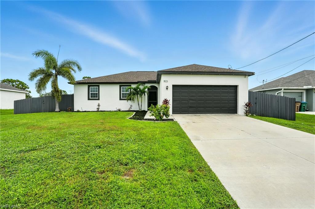 Ranch-style home featuring stucco siding, driveway, a garage, and a shingled roof