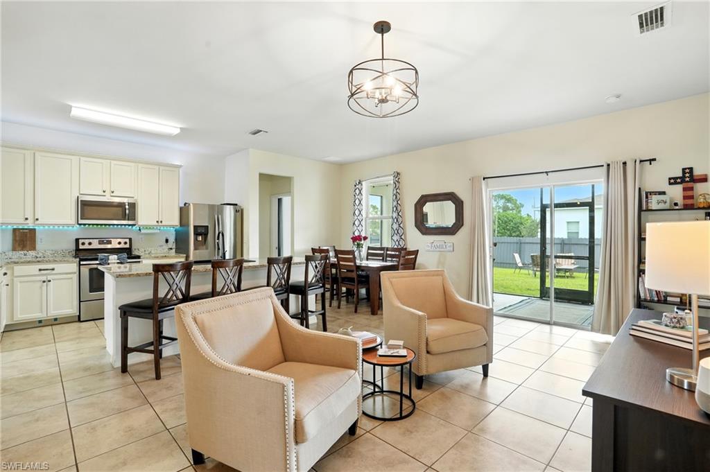Living room with light tile patterned floors and a chandelier