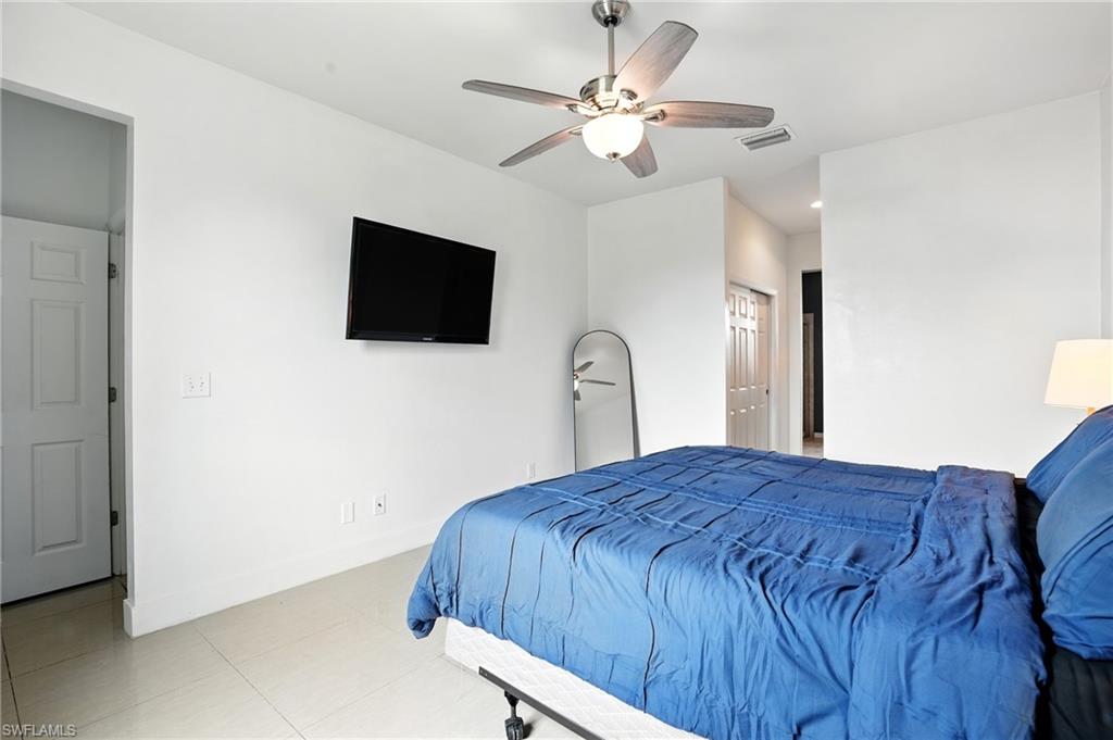 Bathroom with plenty of natural light, double vanity, light tile patterned flooring, and a stall shower