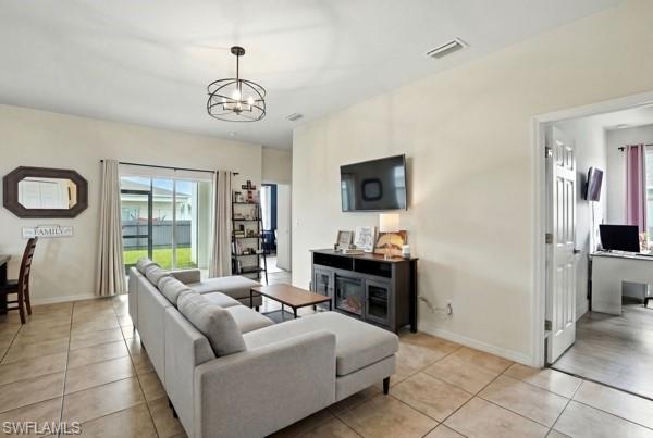 Living area featuring light tile patterned floors and a chandelier