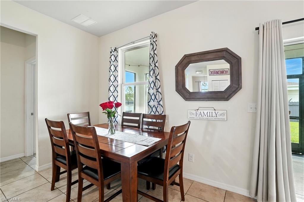 Dining area with light tile patterned floors and baseboards
