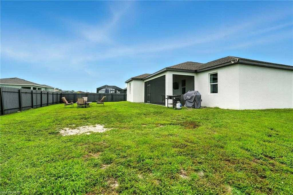 Rear view of property with stucco siding, a sunroom, a pool, and roof with shingles