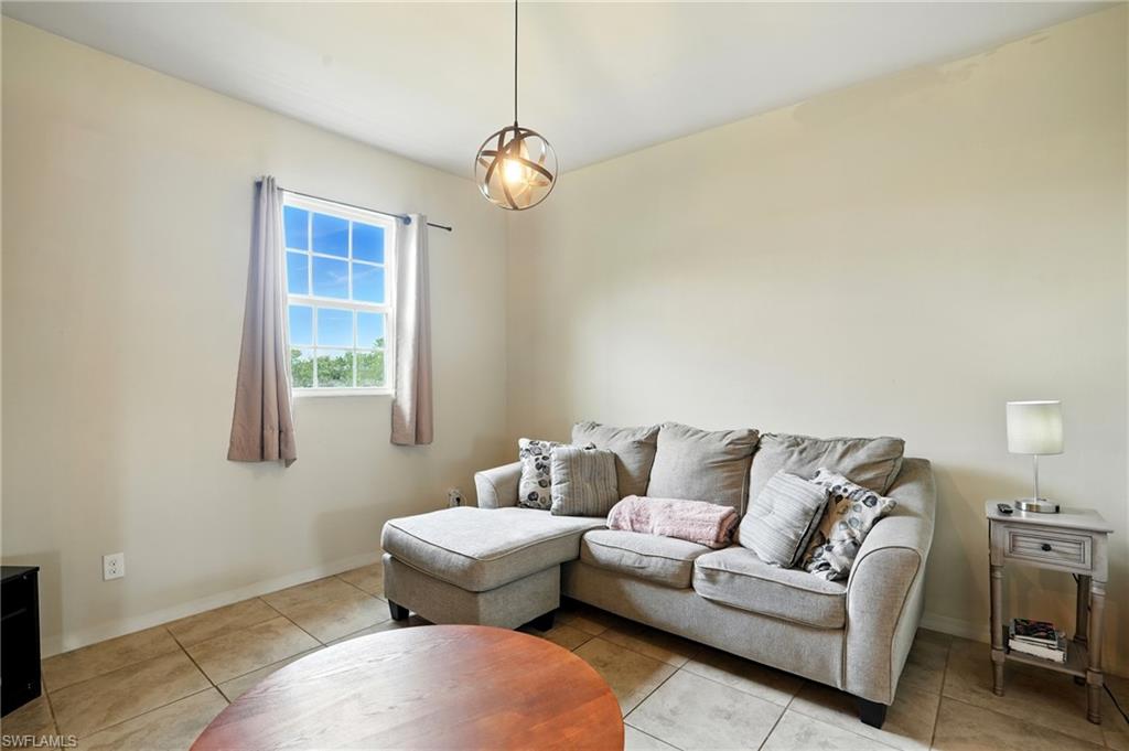 Living room with light tile patterned floors and baseboards