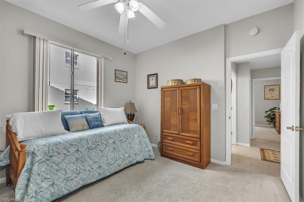 Carpeted bedroom with a ceiling fan and baseboards