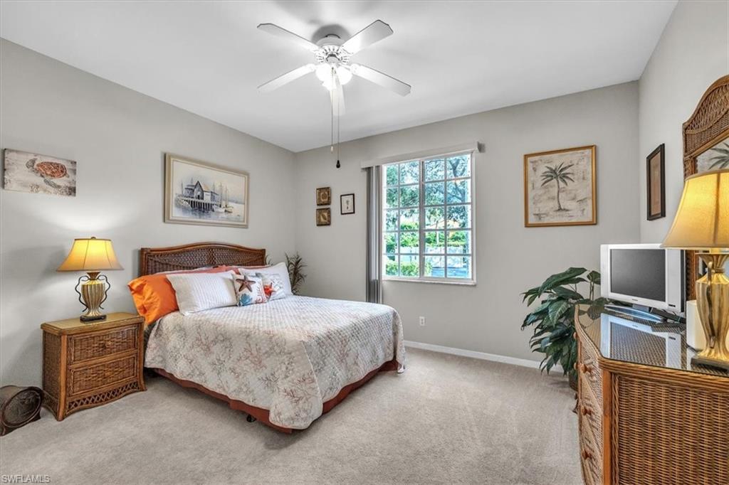 Carpeted bedroom featuring ceiling fan and baseboards