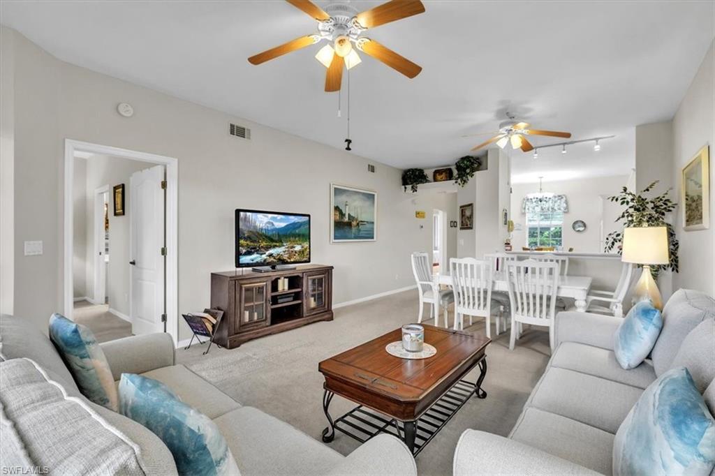 Living area with a ceiling fan and carpet flooring