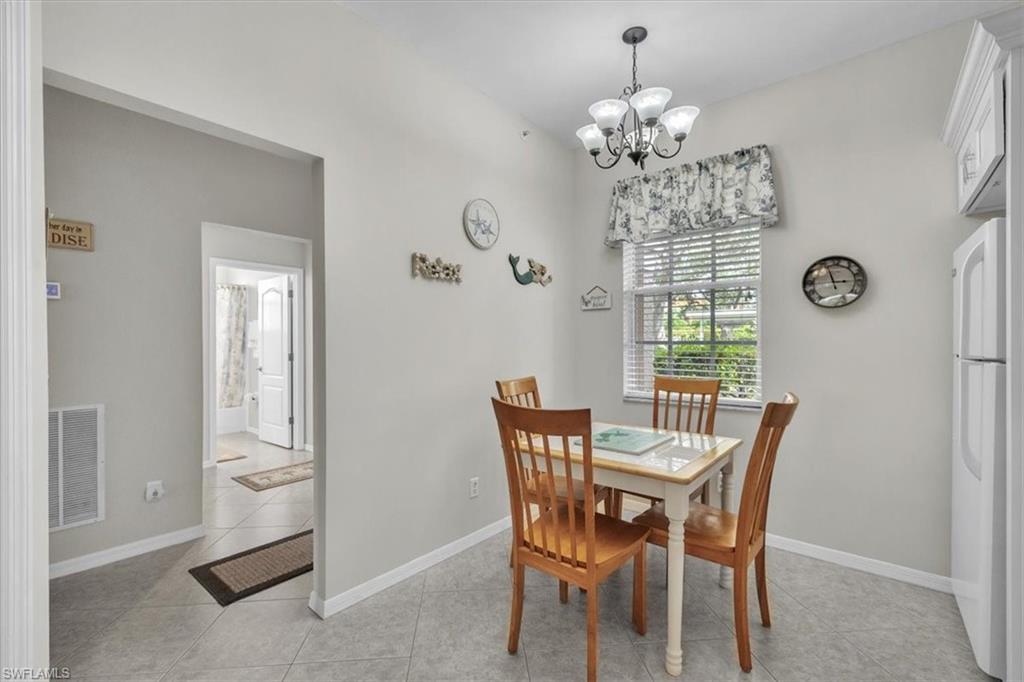 Dining room with light tile patterned flooring and a chandelier