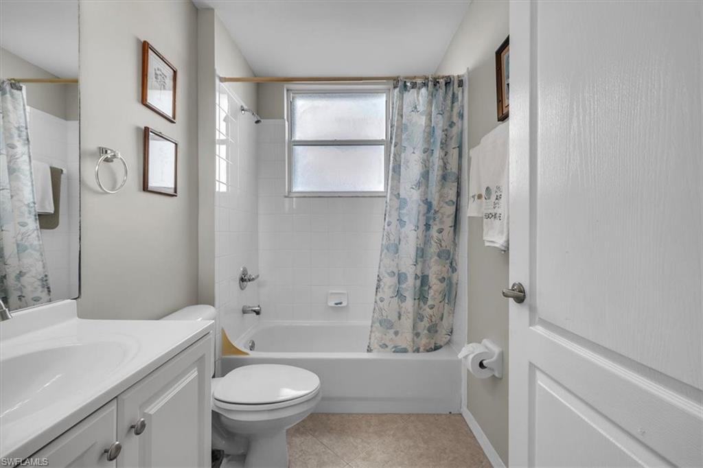 Full bathroom with shower / tub combo, vanity, and light tile patterned floors