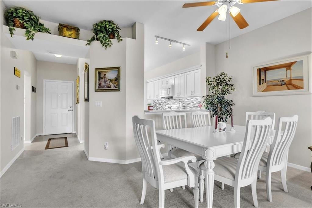Dining space with light carpet and ceiling fan