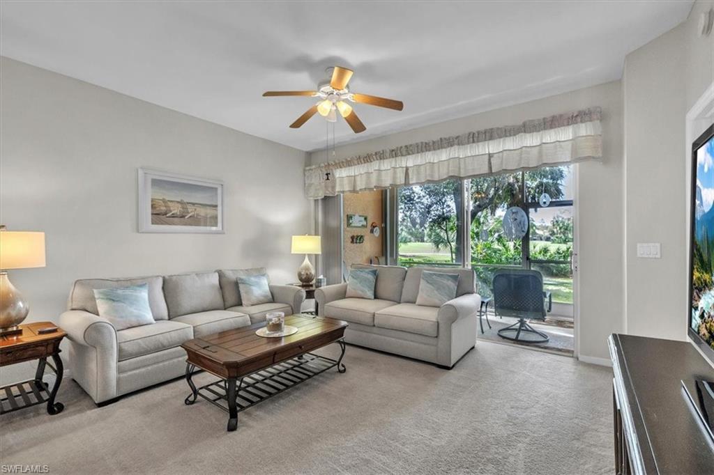 Living room featuring ceiling fan and carpet