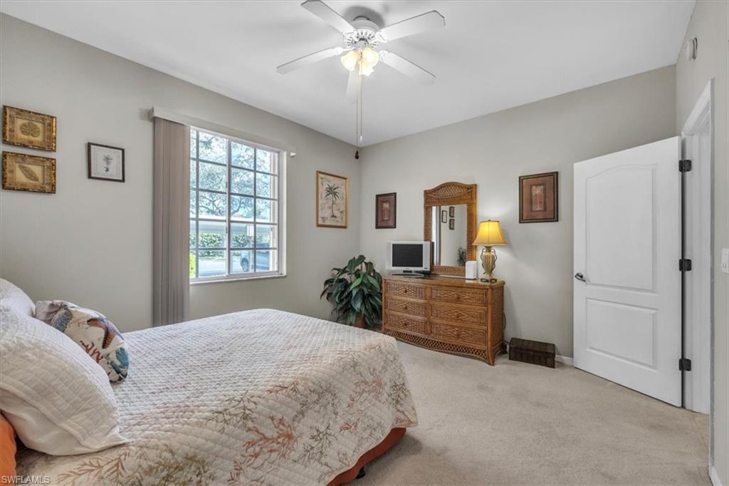 Carpeted bedroom featuring a ceiling fan and baseboards