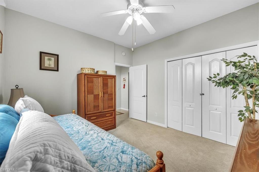 Bedroom with ceiling fan, a closet, and carpet floors