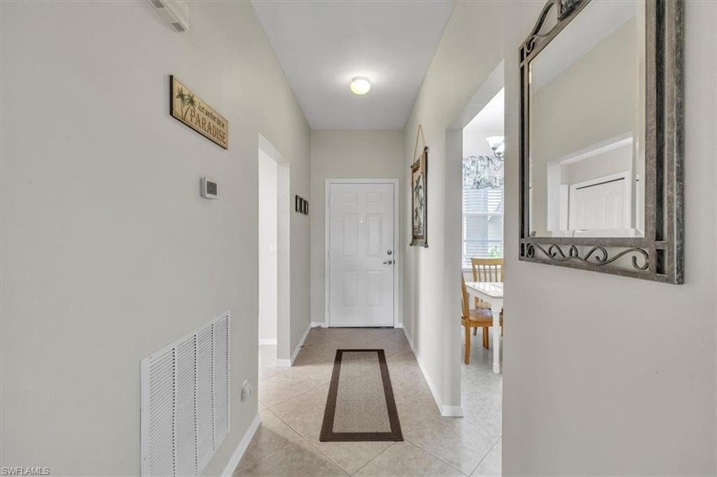 Hall featuring light tile patterned floors and baseboards