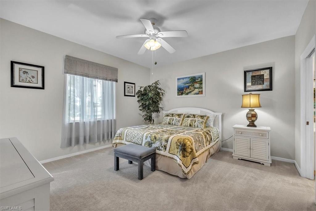 Bedroom with light colored carpet and a ceiling fan