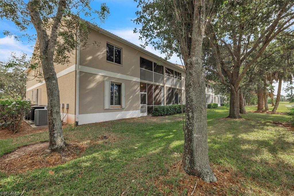Back of house featuring a sunroom, stucco siding, and a yard