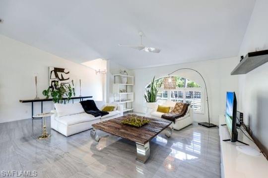 Living room with ceiling fan and lofted ceiling