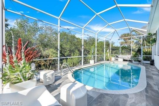 View of swimming pool featuring a lanai and a patio