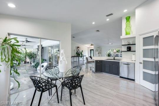 Dining room featuring french doors, ceiling fan, sink, and vaulted ceiling