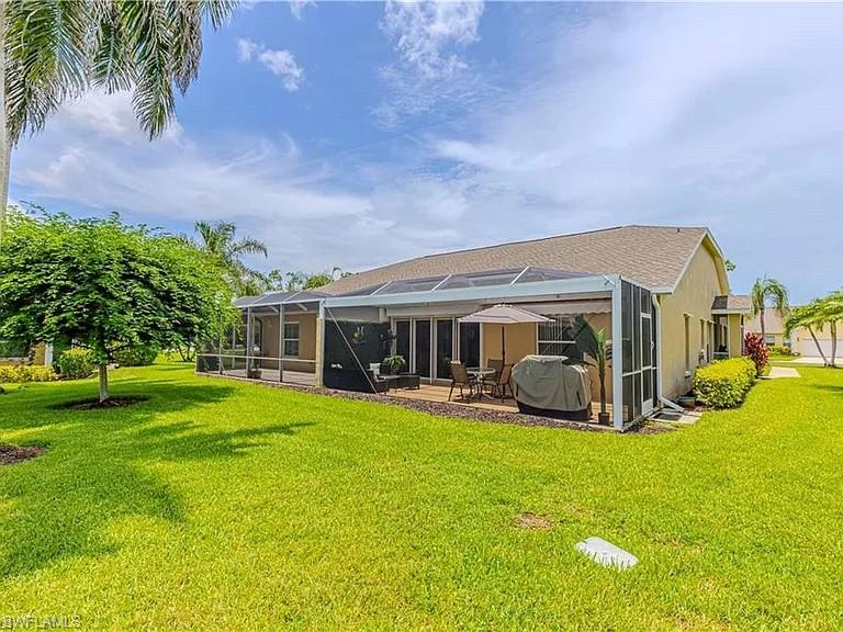 Back of property featuring a lanai, a yard, a sunroom, and a patio
