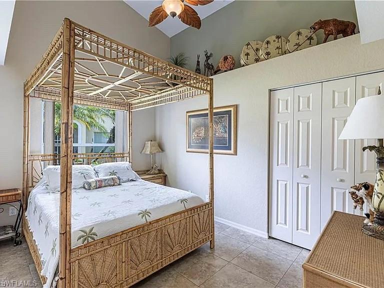 Bedroom with a closet, tile patterned floors, and ceiling fan